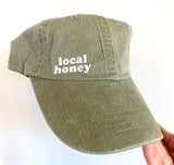 local honey twill pigment dyed dad hat. khaki.heat pressed lower case lettering.